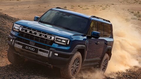 Blue Jetour G700 powering through desert terrain.