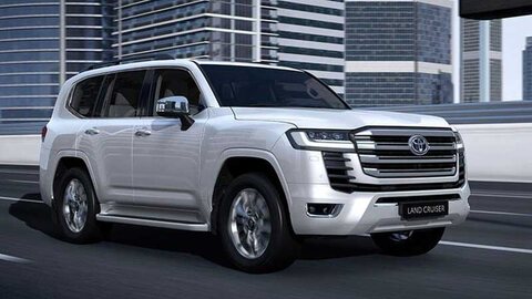 White Toyota Land Cruiser LC 300 on a city highway.